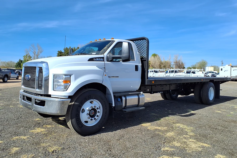 White Ford F-650 regular cab with a black steel flatbed