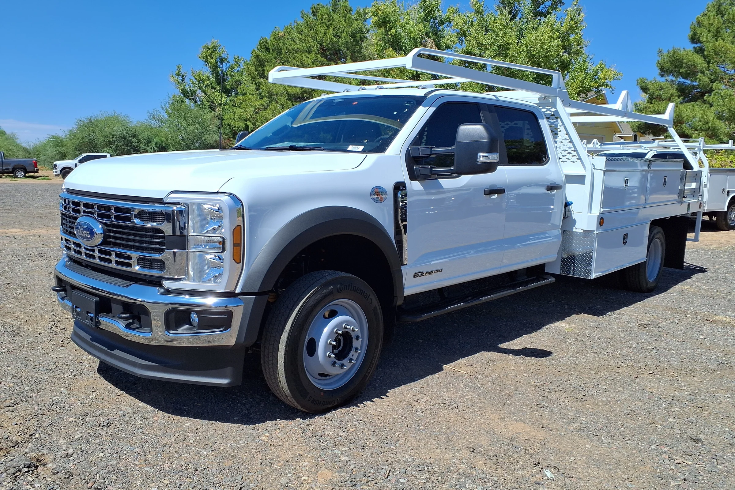 White Ford F-550 Super Duty chassis cab truck with a utility body and ladder rack